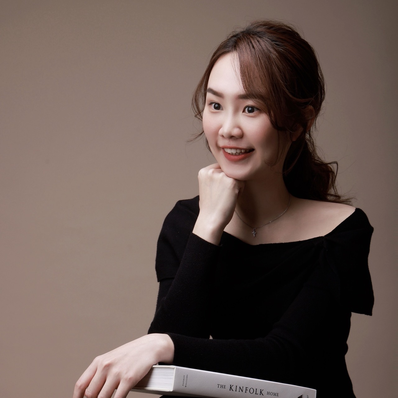 王彥婷 Tina 坐姿肖像,雙手扶著一本書